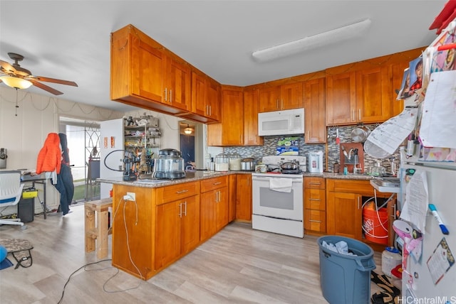 kitchen with white appliances, brown cabinetry, decorative backsplash, light stone counters, and light wood-type flooring