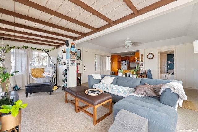 living room featuring light carpet, beamed ceiling, and a ceiling fan