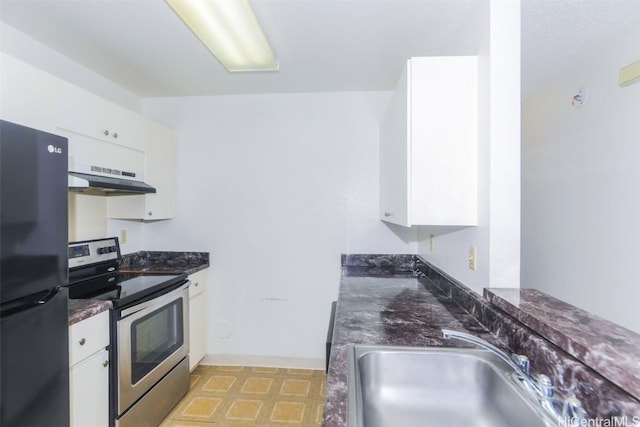 kitchen with freestanding refrigerator, white cabinets, stainless steel range with electric cooktop, and a sink