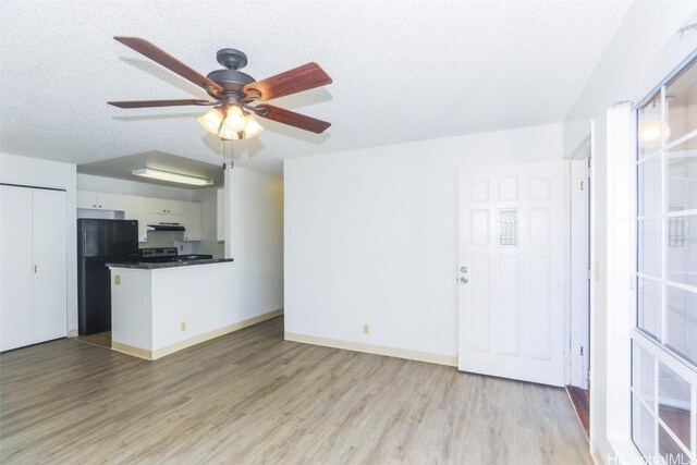 unfurnished living room featuring light wood-style floors and a textured ceiling