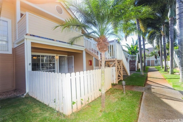 view of home's exterior with fence and stairway