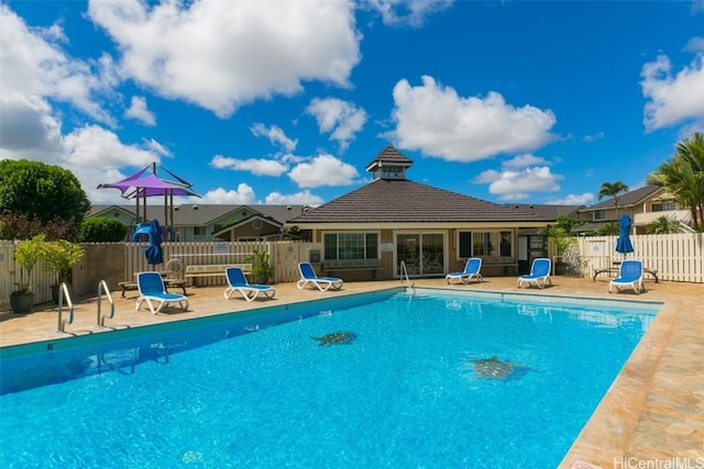 community pool featuring fence and a patio