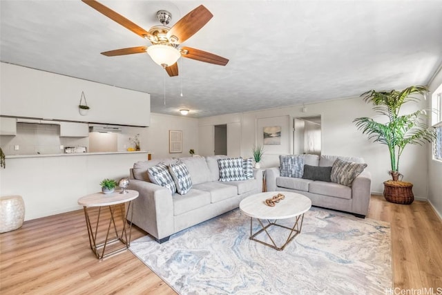 living room with ceiling fan and wood finished floors