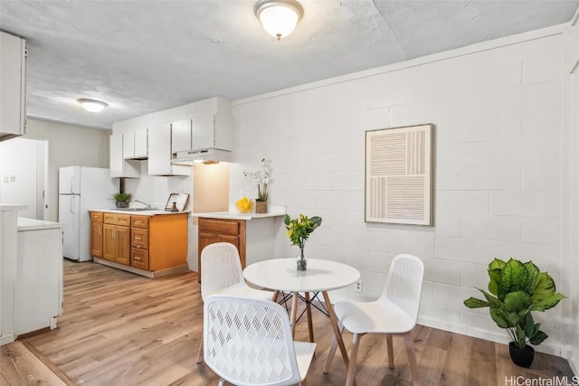 interior space featuring light wood-type flooring and concrete block wall