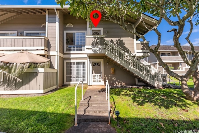 view of front of home featuring stairs and a front lawn