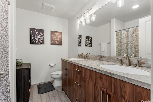 94-1251 Hale Halawai Dr Unit 6, Waipahu, HI 96797 - bathroom featuring double vanity, wood finished floors, toilet, and baseboards
