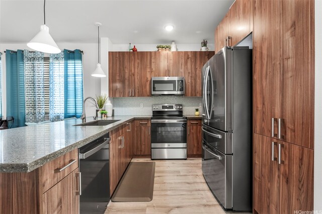 94-1251 Hale Halawai Dr Unit 6, Waipahu, HI 96797 - kitchen with stainless steel appliances, a sink, a peninsula, brown cabinetry, and dark stone counters