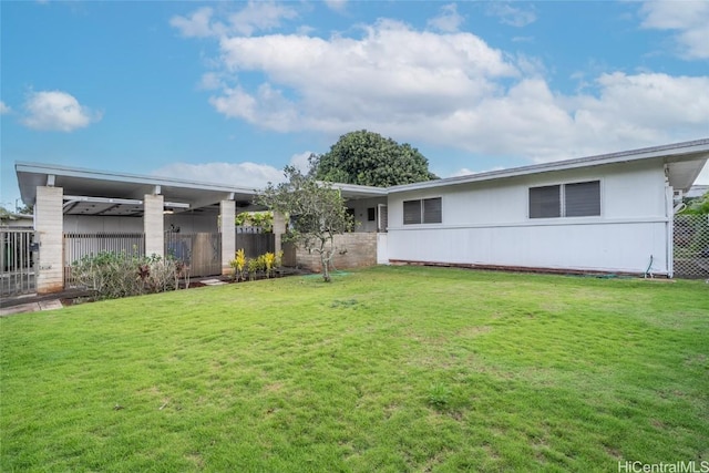 back of house featuring a yard and fence