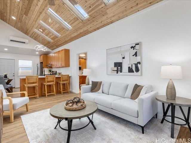 living area featuring light wood-type flooring, high vaulted ceiling, a wall unit AC, a skylight, and wood ceiling