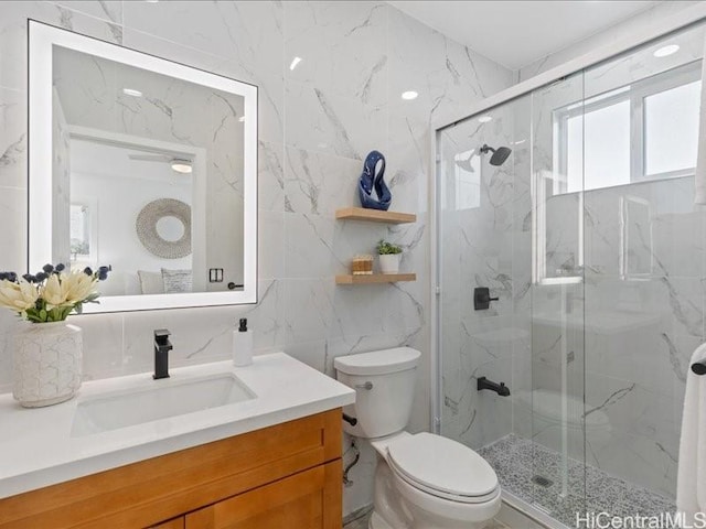 full bathroom with a marble finish shower, toilet, tile walls, and vanity