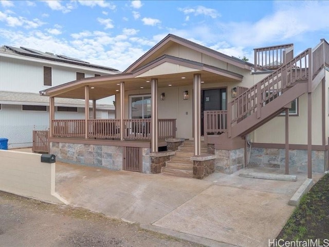 view of front of home featuring stairs and covered porch