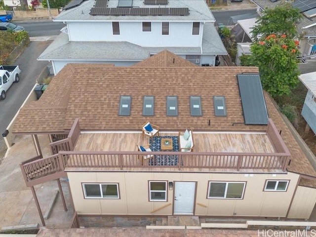 exterior space featuring solar panels and roof with shingles