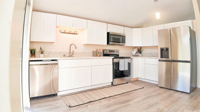 1296 Kapiolani Blvd Unit Ii-2509E, Honolulu, HI 96814 - kitchen with stainless steel appliances, a sink, light countertops, light wood-style floors, and vaulted ceiling