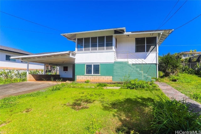 view of front of property with driveway, stairway, a front lawn, and an attached carport