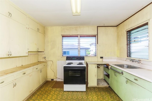 kitchen with dark floors, light countertops, a sink, and electric range