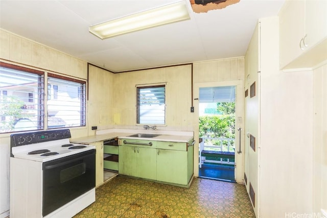 kitchen featuring white electric range oven, tile patterned floors, light countertops, a healthy amount of sunlight, and a sink