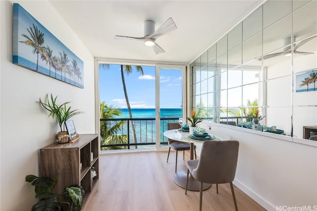 sunroom / solarium with a water view and ceiling fan