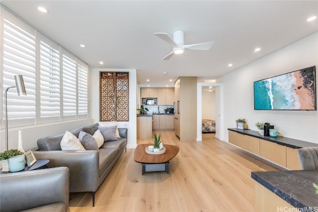 living area with light wood-style floors, ceiling fan, and recessed lighting