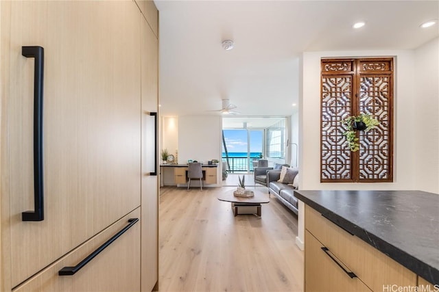 interior space featuring ceiling fan, light wood-style flooring, recessed lighting, light brown cabinetry, and dark countertops