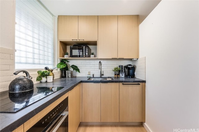 kitchen with decorative backsplash, light wood-style floors, black appliances, open shelves, and a sink