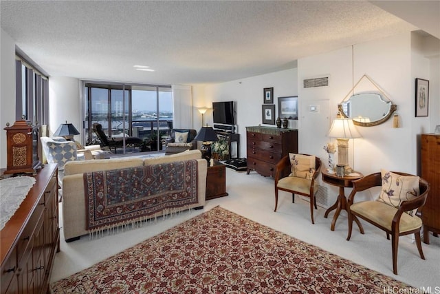 carpeted living room with expansive windows, visible vents, and a textured ceiling