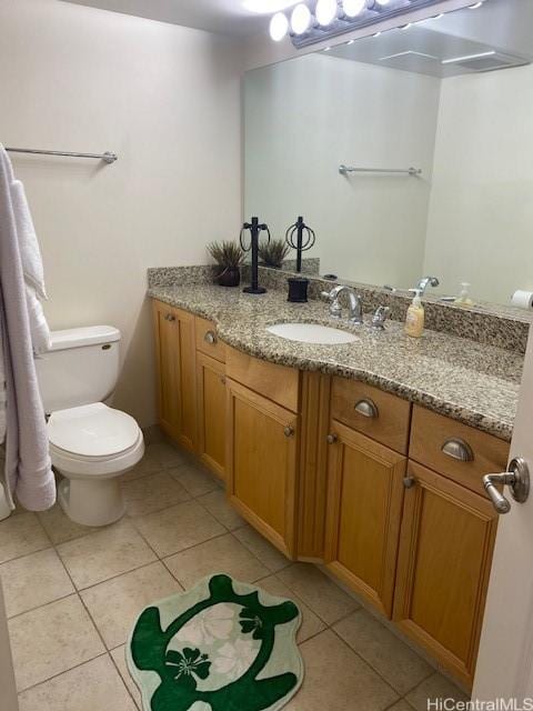 bathroom with tile patterned flooring, vanity, and toilet