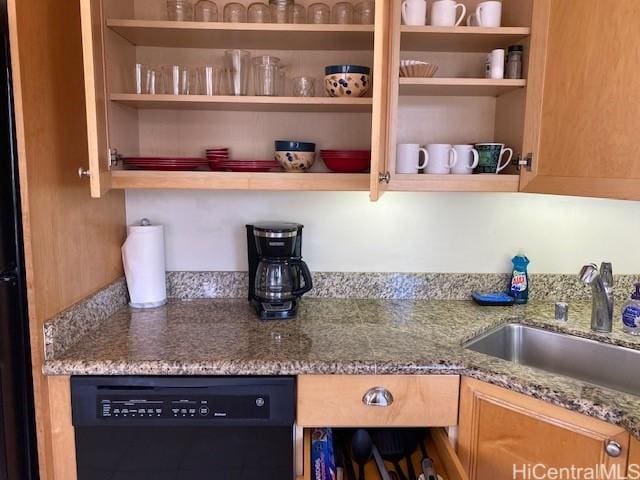 kitchen featuring light stone countertops, black dishwasher, a sink, and open shelves