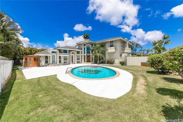 back of house with a fenced in pool, a yard, stucco siding, a patio area, and a fenced backyard