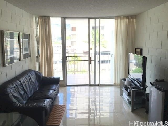 2714 Kahoaloha Ln Unit 503, Honolulu, HI 96826 - living room featuring concrete block wall and a wall of windows