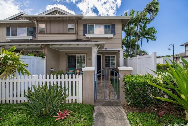 view of front of home featuring a fenced front yard, a gate, a porch, and board and batten siding