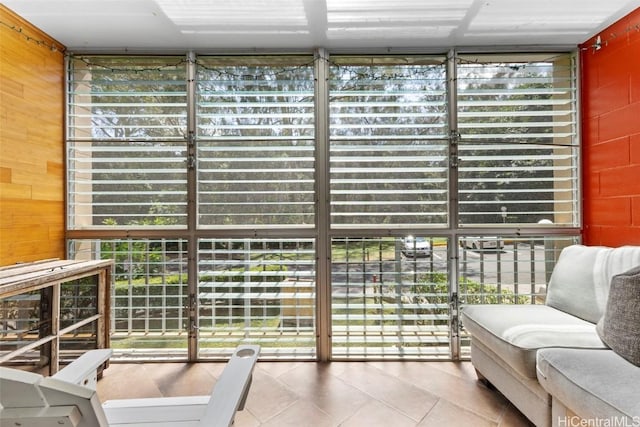 interior space with expansive windows, wood walls, and tile patterned floors