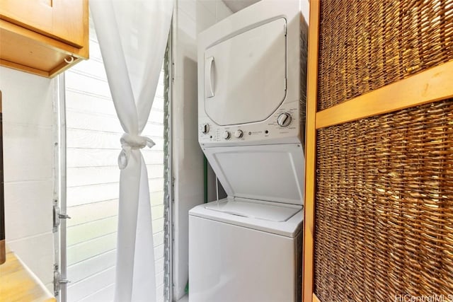 clothes washing area with laundry area and stacked washer and clothes dryer