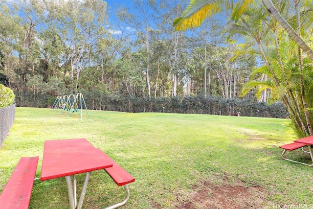 view of property's community featuring playground community and a lawn