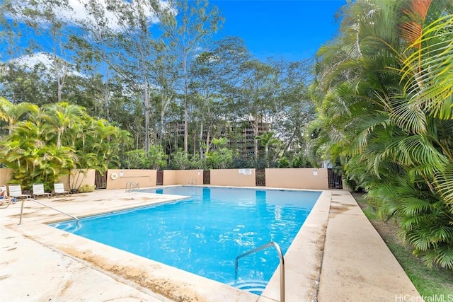 pool with a patio and fence