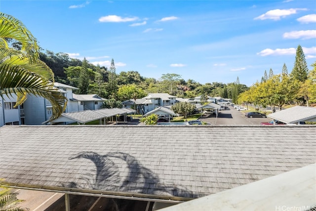 details with a shingled roof, a residential view, and parking