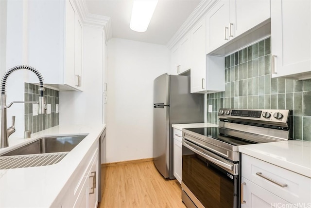 kitchen with appliances with stainless steel finishes, light countertops, a sink, and decorative backsplash