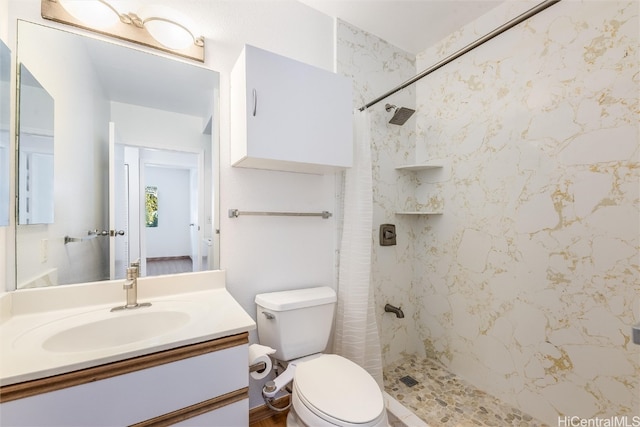 bathroom featuring a stall shower, vanity, and toilet