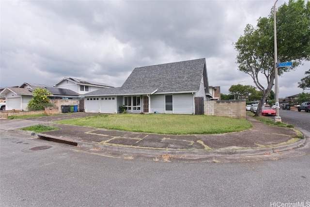 view of front of home with aphalt driveway, a shingled roof, an attached garage, fence, and a front lawn