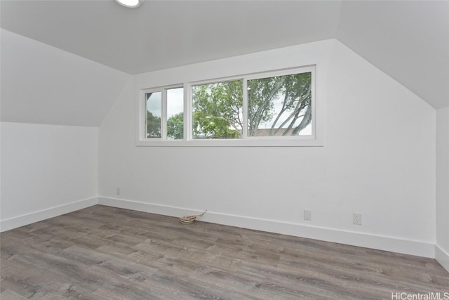 additional living space with lofted ceiling, baseboards, and wood finished floors