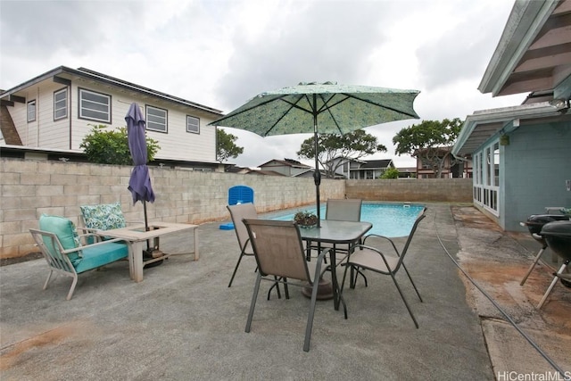 view of patio / terrace featuring outdoor dining space, a fenced backyard, and a fenced in pool