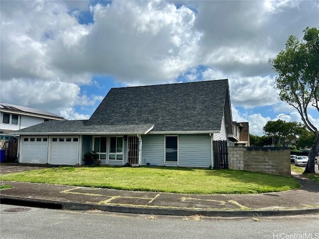 view of front of home with roof with shingles, an attached garage, a front yard, fence, and driveway