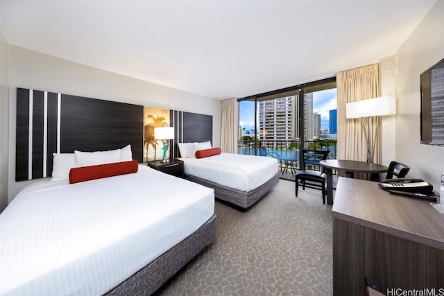 carpeted bedroom featuring a wall of windows