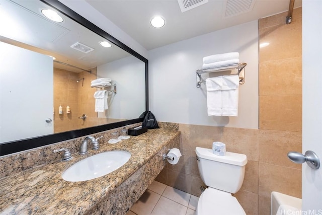 bathroom with a sink, visible vents, and tile walls