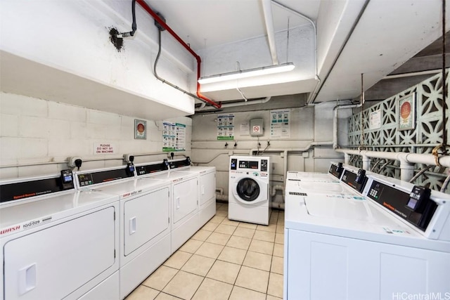 shared laundry area featuring light tile patterned floors and washer and clothes dryer