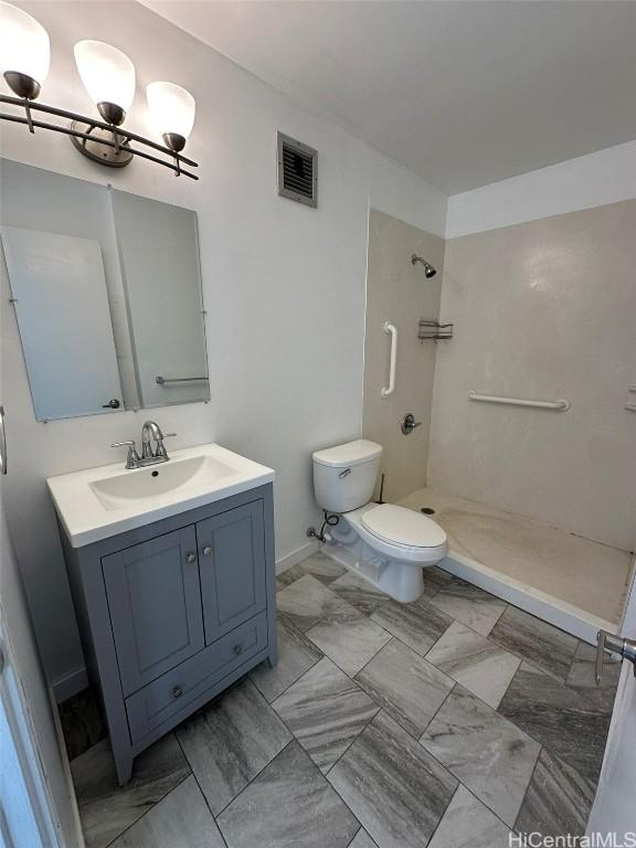 bathroom featuring toilet, a shower stall, visible vents, and vanity