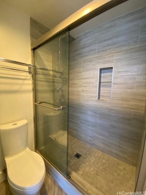 bathroom with toilet and a shower stall