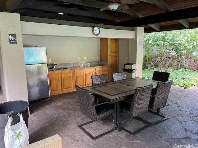 view of patio featuring exterior kitchen, outdoor dining area, ceiling fan, and a sink