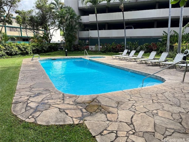 community pool with a community hot tub and a patio area