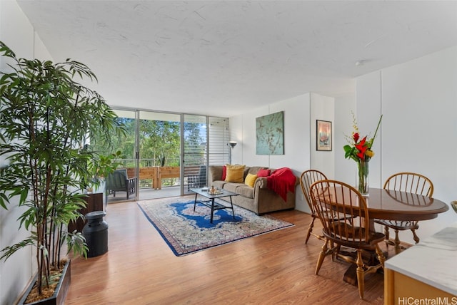 living room featuring a wall of windows, a textured ceiling, and wood finished floors