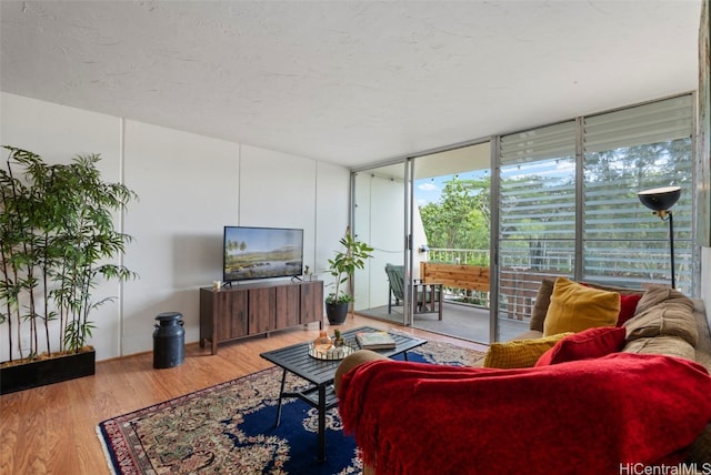 living room featuring expansive windows, a textured ceiling, and wood finished floors